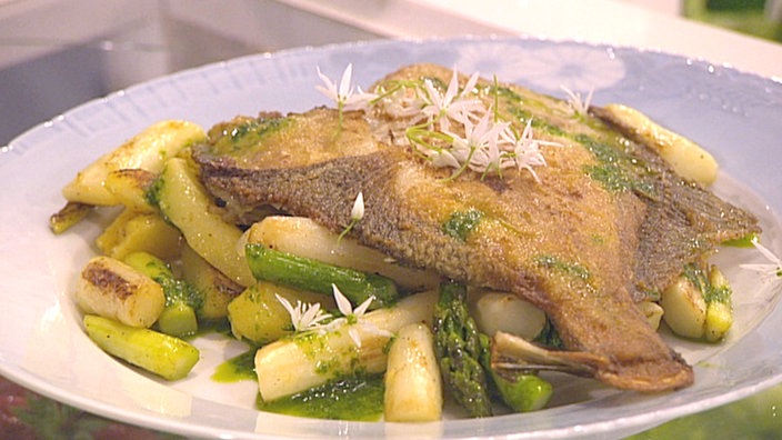 Gebratener Spargel mit gebratenem Fisch auf einem Teller angerichtet