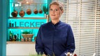 Julia Komp in der Küche mit Kräuternin der Hand.