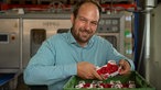 Benedikt Böcker mit einer Kiste Himbeeren. 