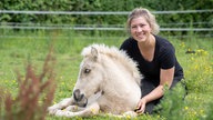 Cindy Vollmer-Halsband kuschelt mit einem Fohlen. 