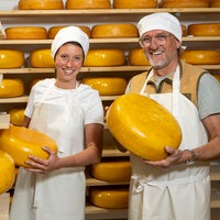 Antje van 't Klooster und Frank Buchholz mit großen Goudas in den Händen. 