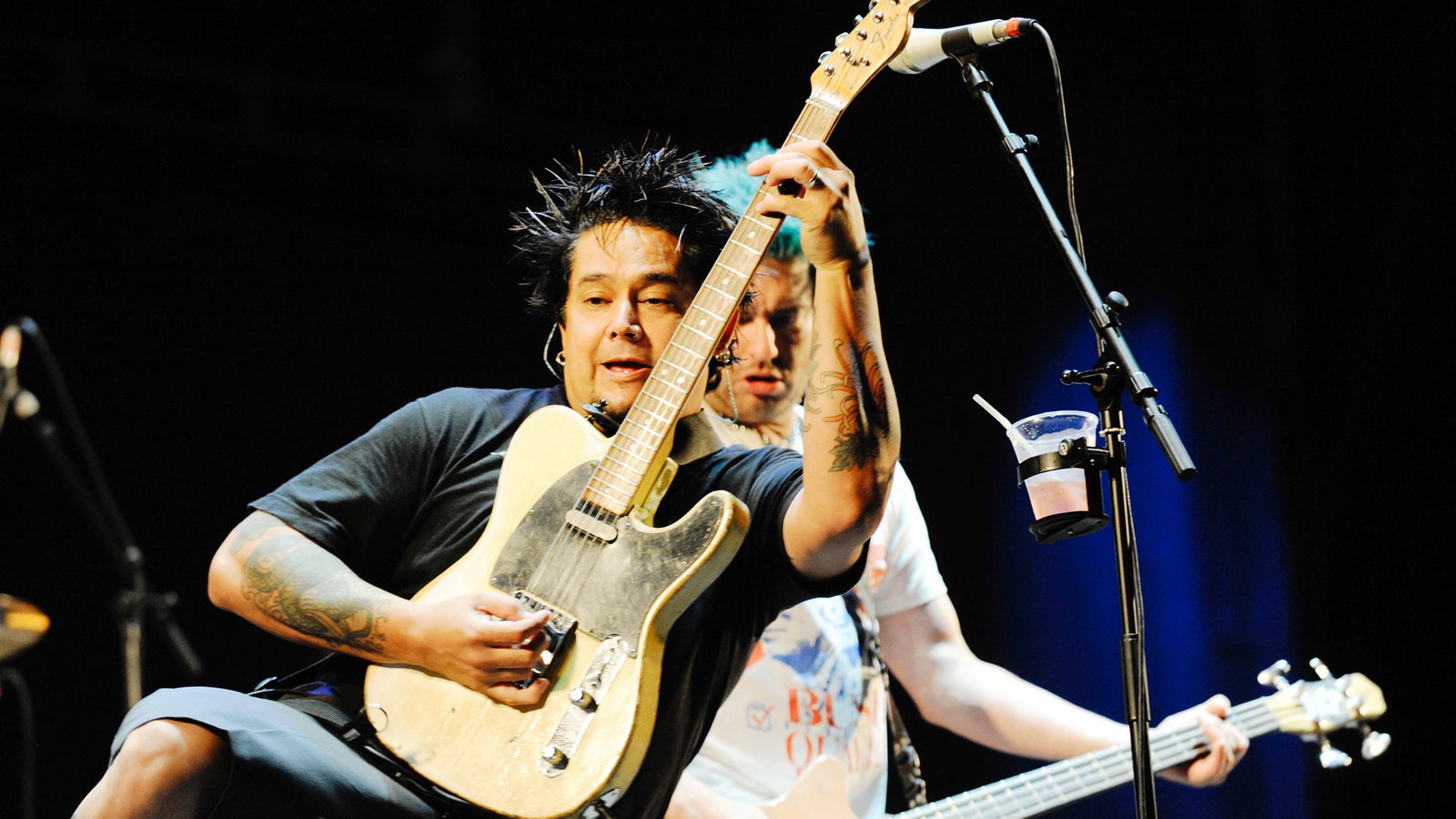 Gitarrist von Nofx hält sein Instrument nach oben und lehnt sich zurück