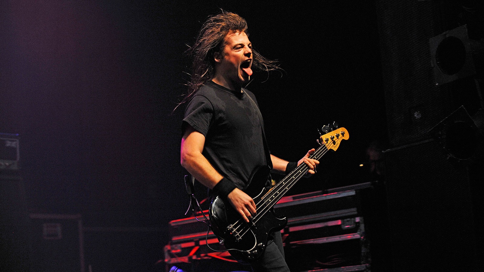 Mit heraushängender Zunge spielt der Bassist sein instrument