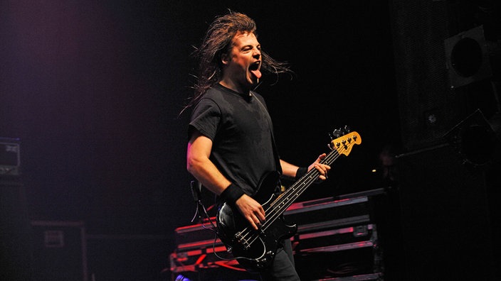 Mit heraushängender Zunge spielt der Bassist sein instrument