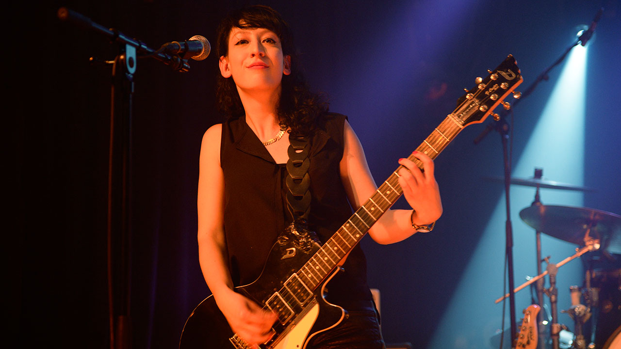 Gitarristin von Angelika Express spielt zufrieden einen Akkord auf ihrer Düsenberg Gitarre (teuer)