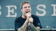 Singend hält der Frontmann das Mikro mit beiden Händen fest