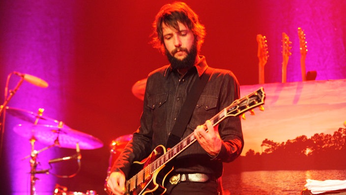 Der Sänger der "Band of Horses" steht mit elektronischer Gitarre auf der Bühne