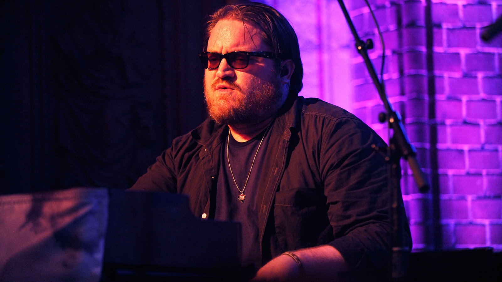 Der Band-Pianist trägt Vollbart und sitzt vor dem Keyboard