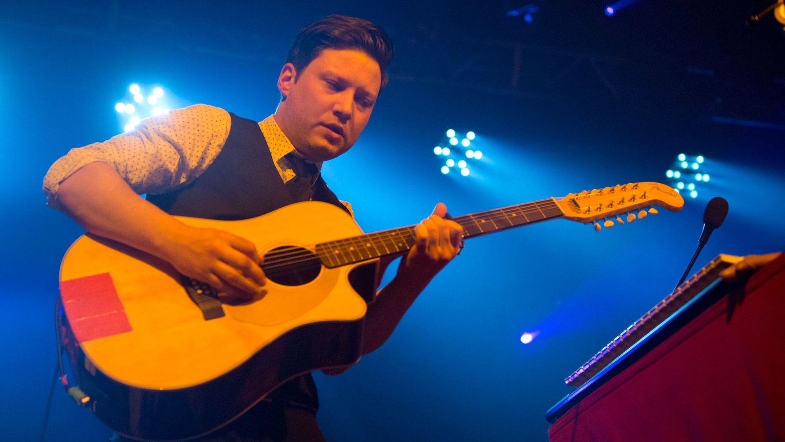 Frontmann von Get Well Soon mit Akustikgitarre von unten fotografiert