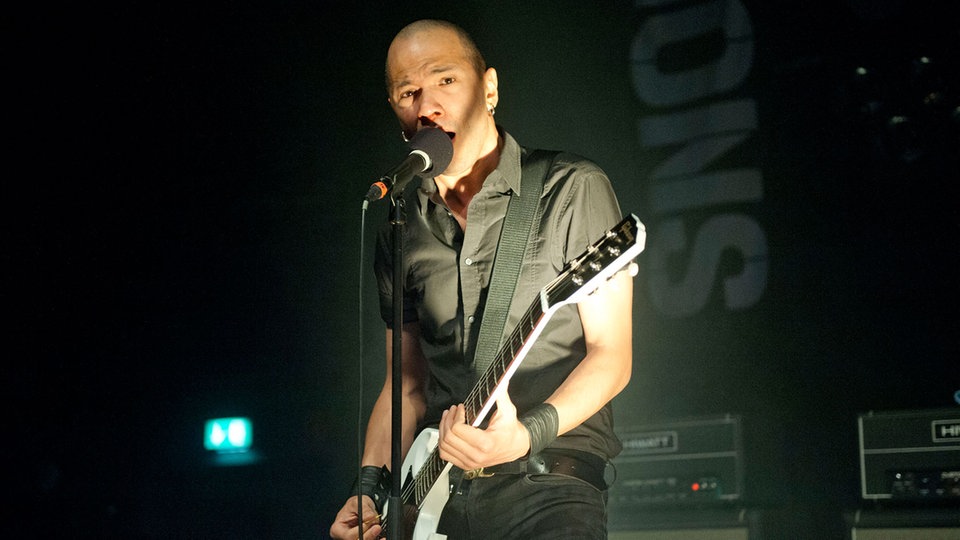 Danko Jones ist im Licht eines Spotlights am performen.