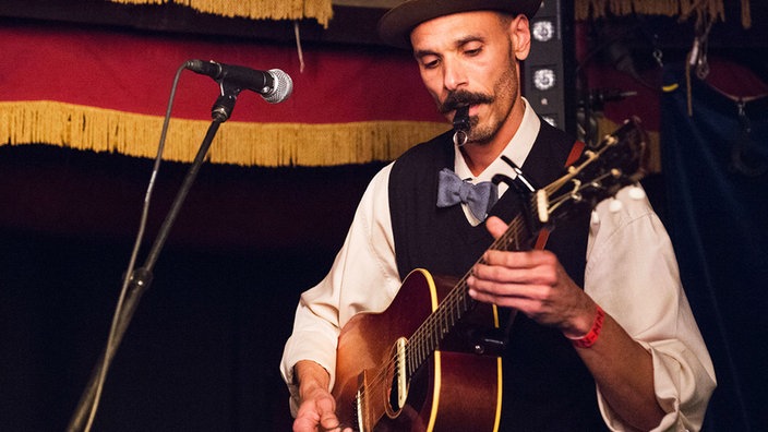 Der Gitarrist der Band mit einer Pfeife im Mund