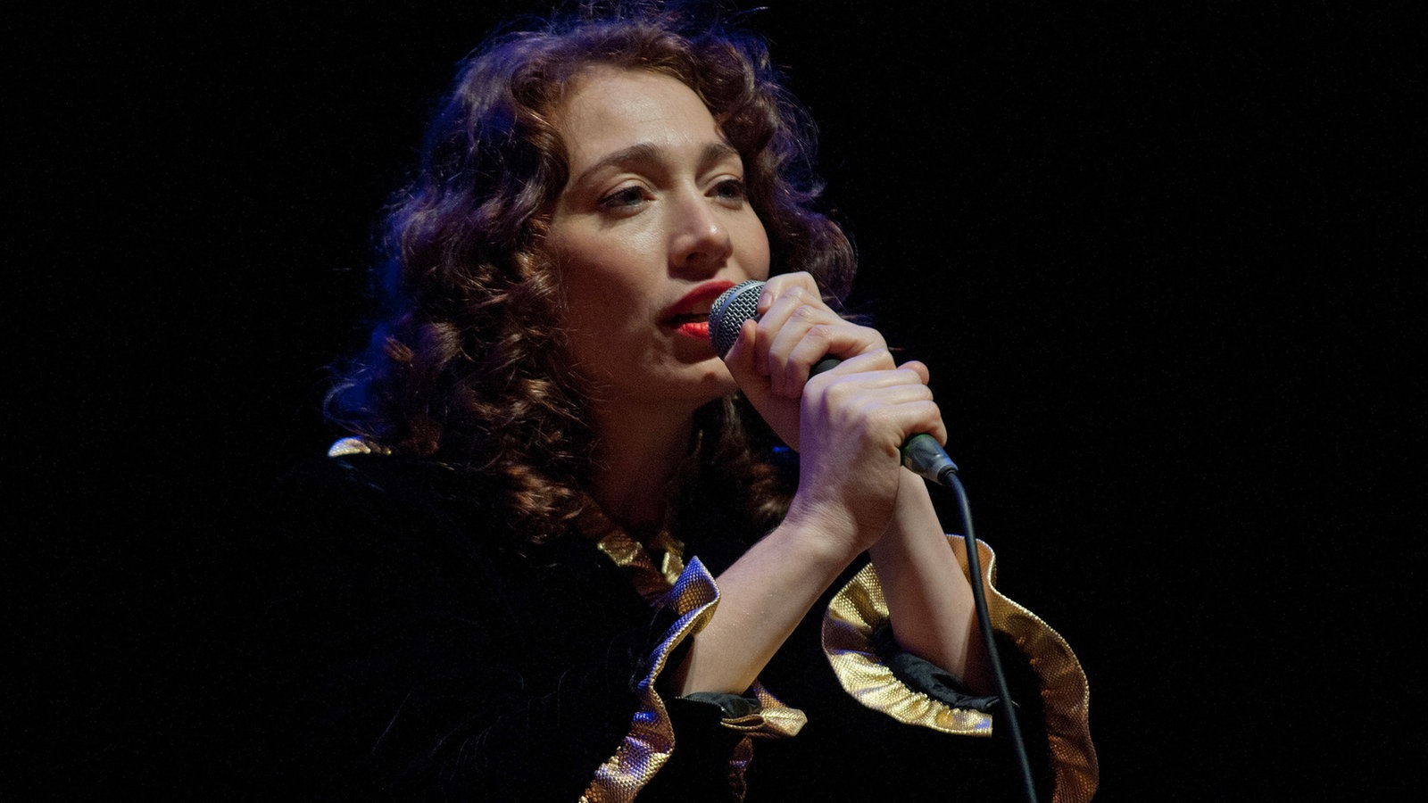 Regina Spector singt ins Mikrofon, das sie mit beiden Händen festhält