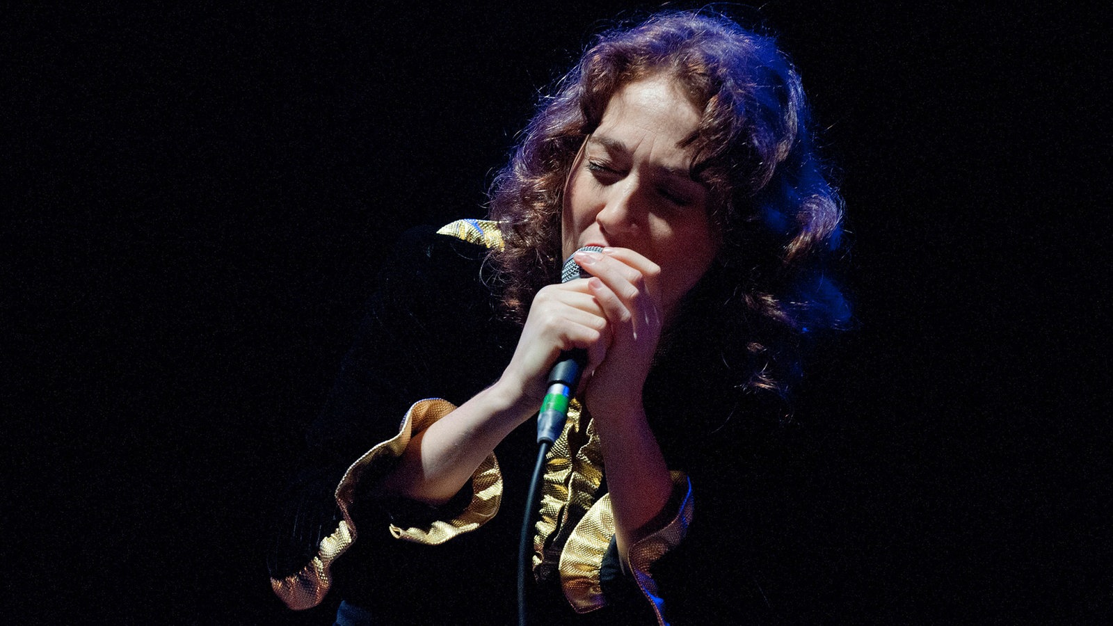 Regina Spector singt mit geschlossenen Augen und hält das Mikro mit beiden Händen fest