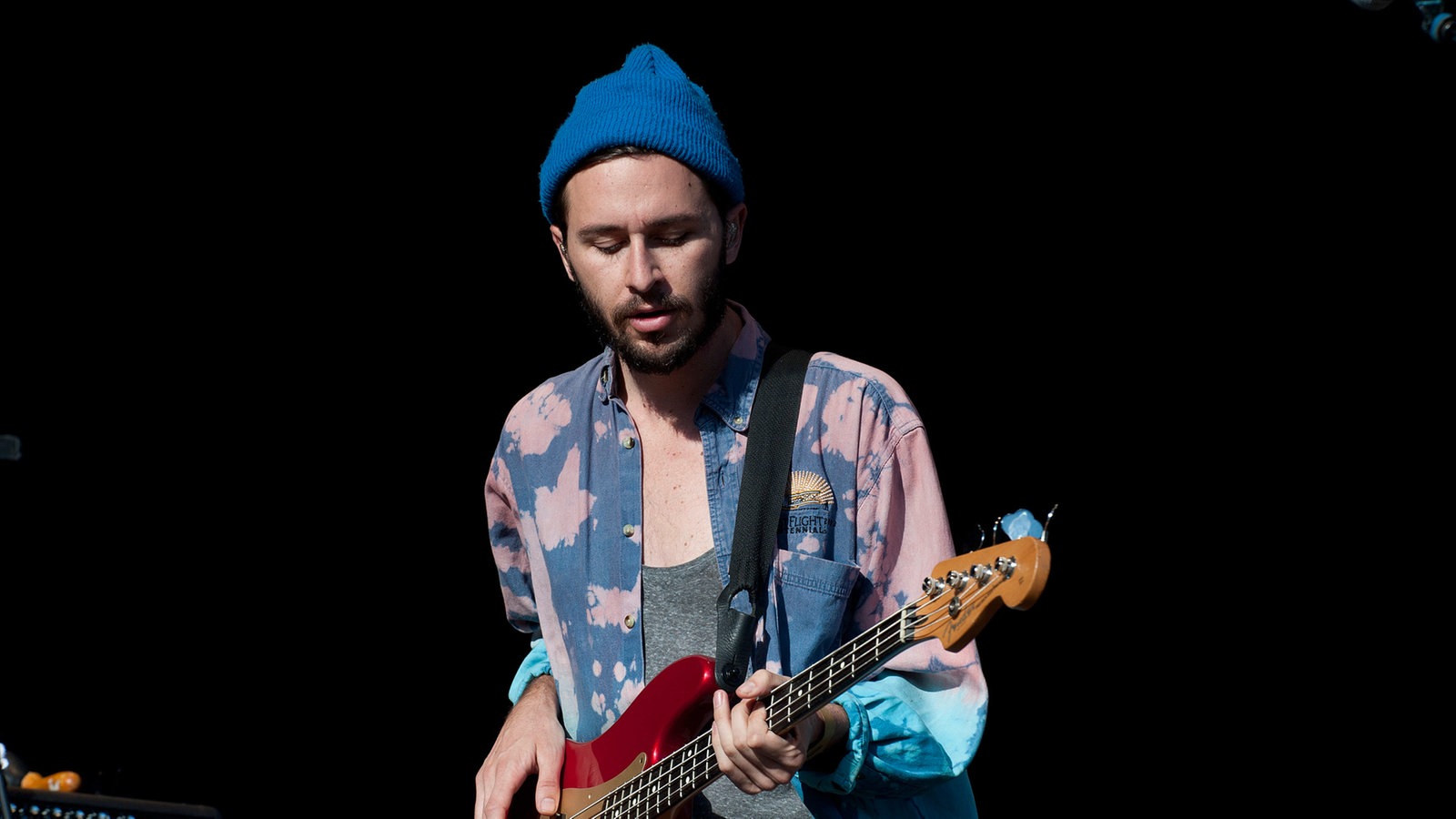 Bassist der Local Natives im gefleckten Hemd und mit blauer Mütze