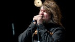 Sänger mit Vollbart und langem Haar singt mit geschlossenen Augen