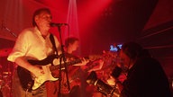 Die Band "Karthago" bei ihrem Auftritt im roten Bühnenlicht.
