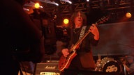 Konzertfoto der Band "Jane" mit Frontmann im Vordergrund.