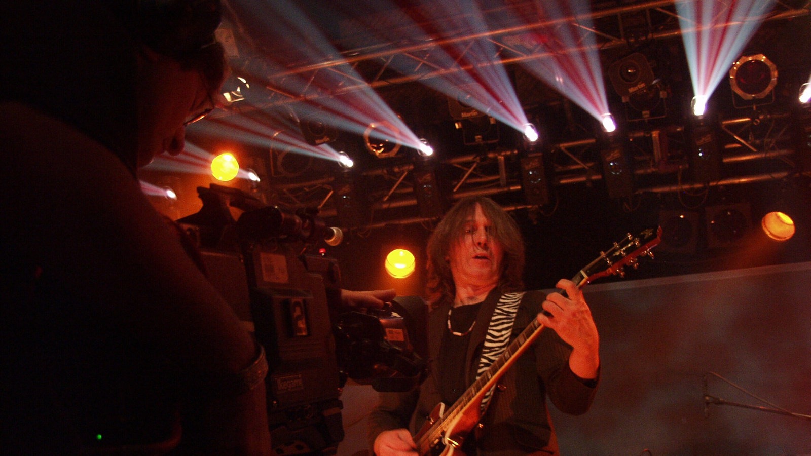 Konzertfoto der Band "Jane" mit Frontmann im Vordergrund.