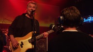 Bassist der Band "Jane" wird von einem Kameramann beim Spielen gefilmt.