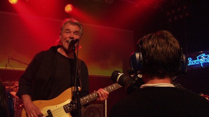 Bassist der Band "Jane" wird von einem Kameramann beim Spielen gefilmt.