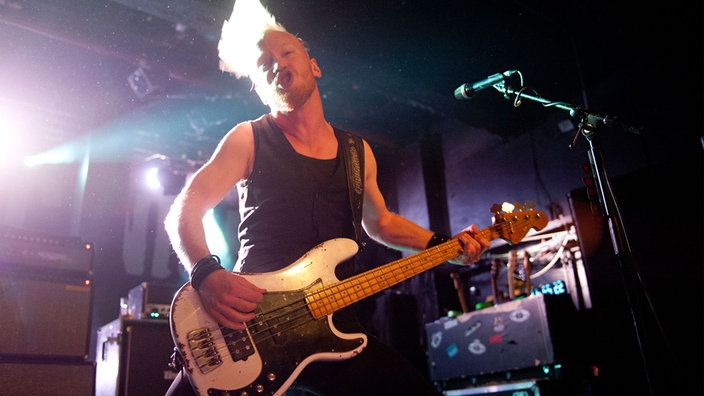 Gitarrist der Band "Royal Republic" steht auf der Bühne und spielt