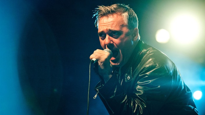 Der Sänger der Band "The Undertones" singt in ein Mikrofon