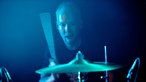 Der Drummer von Breton schlägt erfreut auf sein Drumkit ein.