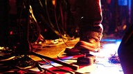Fuß eines Musikers am Pedal eines Effektgeräts.