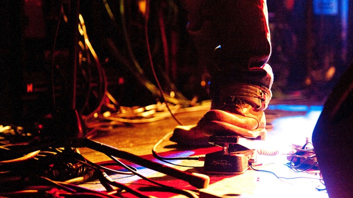 Fuß eines Musikers am Pedal eines Effektgeräts.