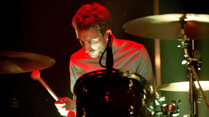 Der Drummer der Band, ebenfalls mit ordentlicher Kurzhaarfrisur und Hemd.