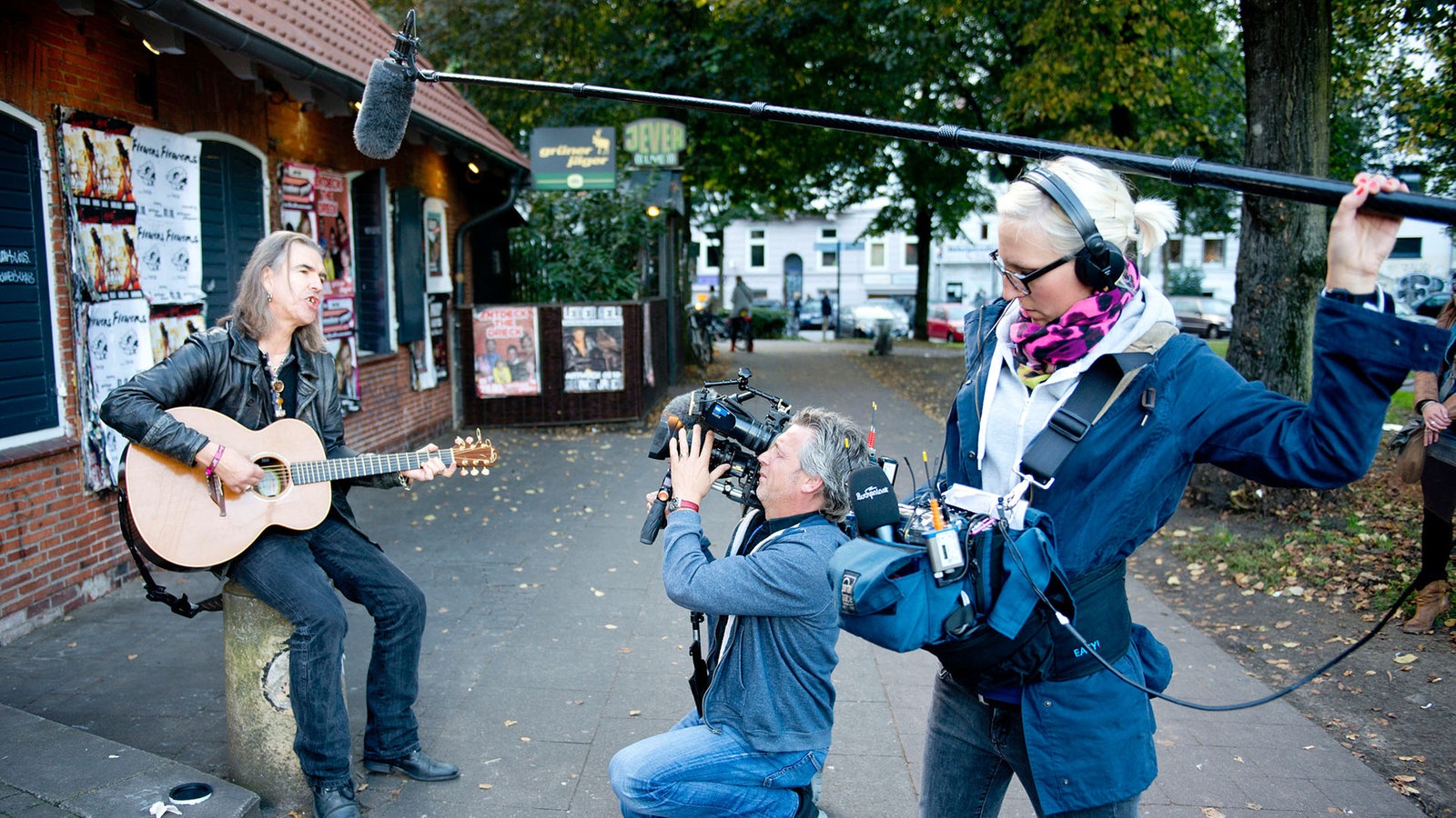 Ein Kamerateam filmt und nimmt den New Model Army Frontman mit seiner Gitarre auf.