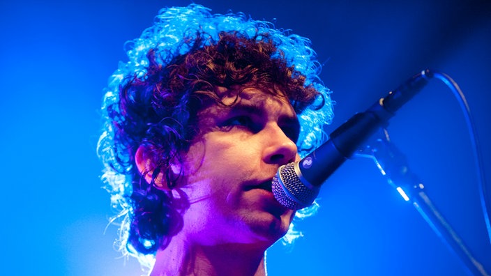 Der lockenköpfige Johannes Leppänen, Sänger und Gitarrist der band French Films, am Mikrofon.