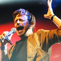 Voller Energie singt dieser Mann auf der Bühne und hebt dabei die linke Hand