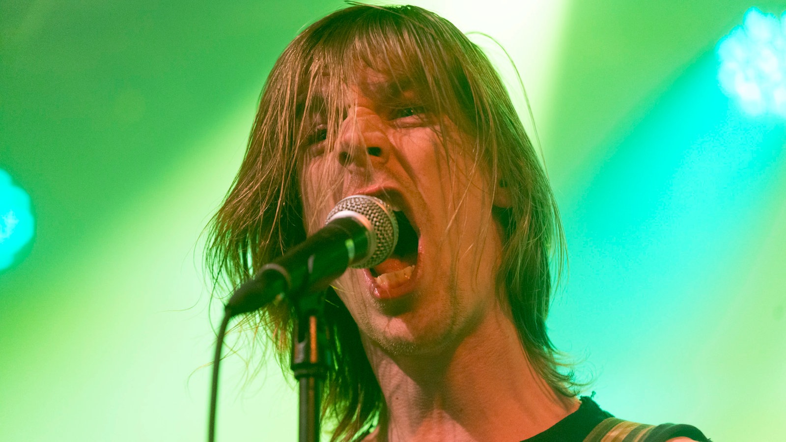 Sänger von John Coffey singt enthusiastisch ins Mikrofon, er sieht ein bisschen aus wie Mike Stern