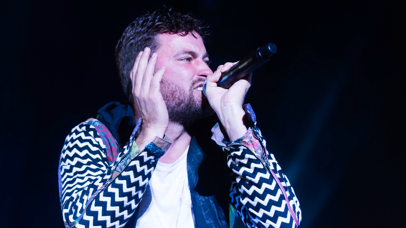 Marteria rappt, dabei hebt er eine Hand auf Kopfhöhe und verzieht sein Gesicht zu einer Fratze.