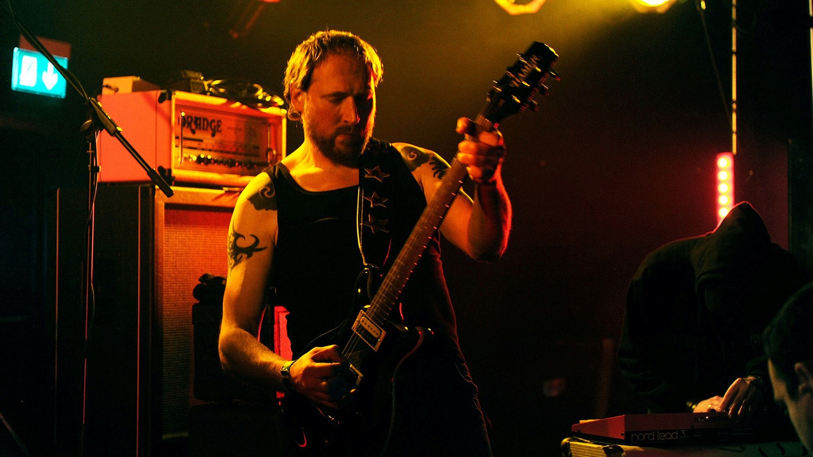 Der Bassist schwingt sein Instrument hochkonzentriert im Scheinwerferlicht
