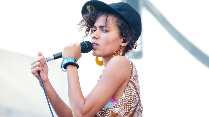 Nneka singt und hat eine Käppi auf