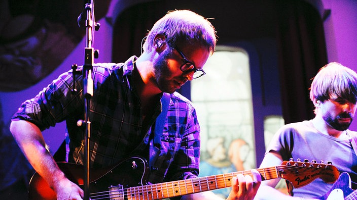 Bandmitglieder von Moss spielen Gitarre auf der Bühne