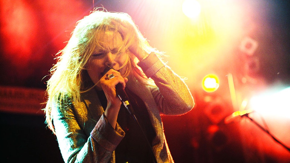 Liela Moss von The Duke Spirit singt mit schmerzverzerrtem Gesicht ins Mikrofon  