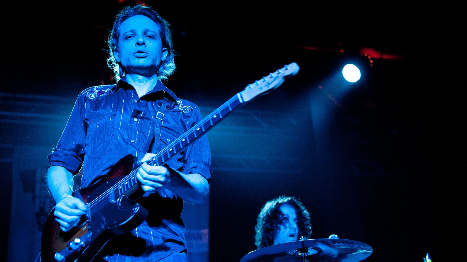 Der Gitarrist von "The Jon Spencer Blues Explosion" steht auf der Bühne undspielt