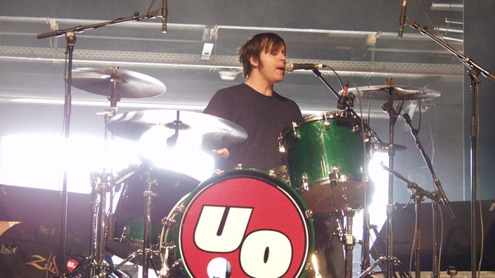 Schlagzeuger der Band "Urge Overkill" spielt Schlagzeug und singt.