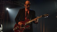 Garbage: Mann mit Gitarre auf der Bühne im Halbdunkeln