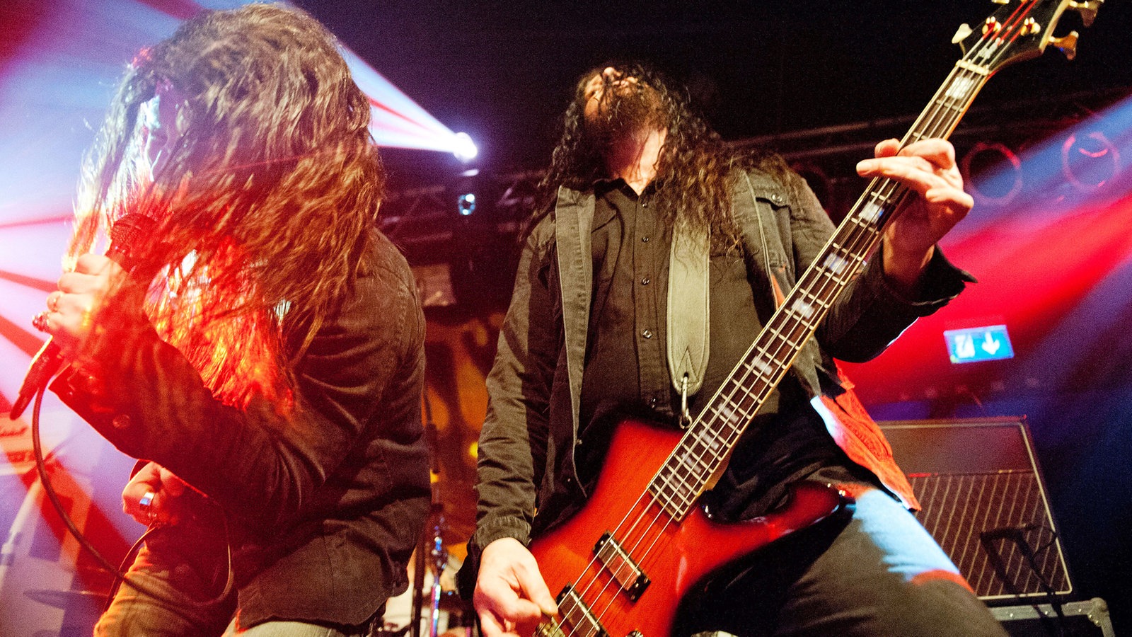 Sänger und Bassist der Spiritual Beggars mit langen Locken im bunten Bühnenlicht.