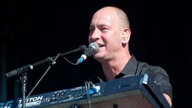 Mann am Keyboard singt ins Mikrofon