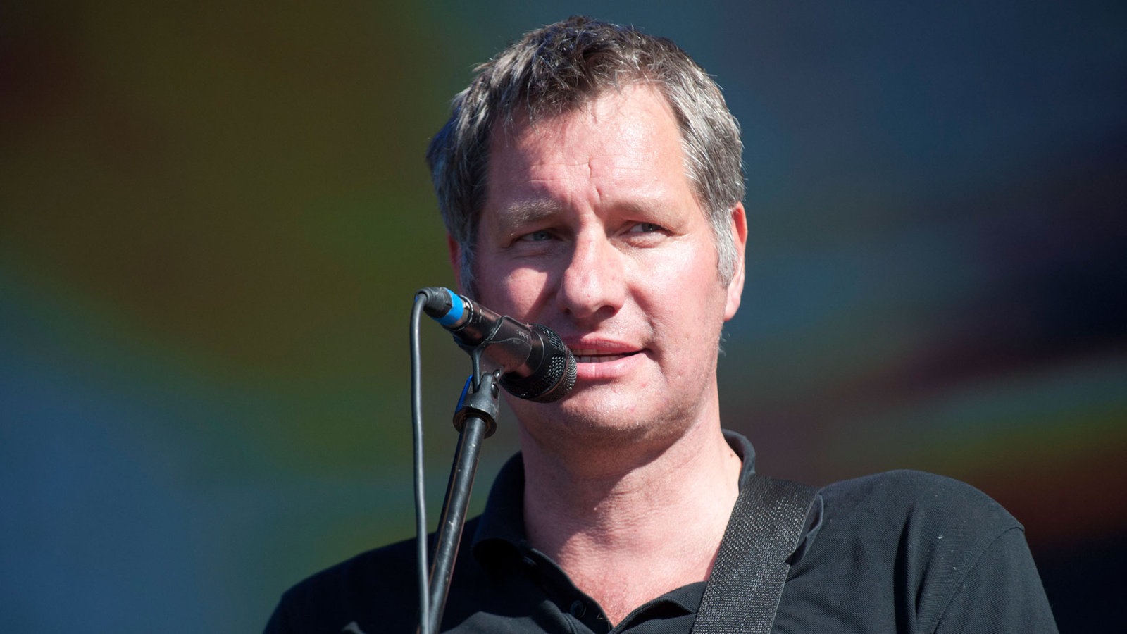 Sänger der Band Kettcar singt ins Mikrofon und blickt zur Seite