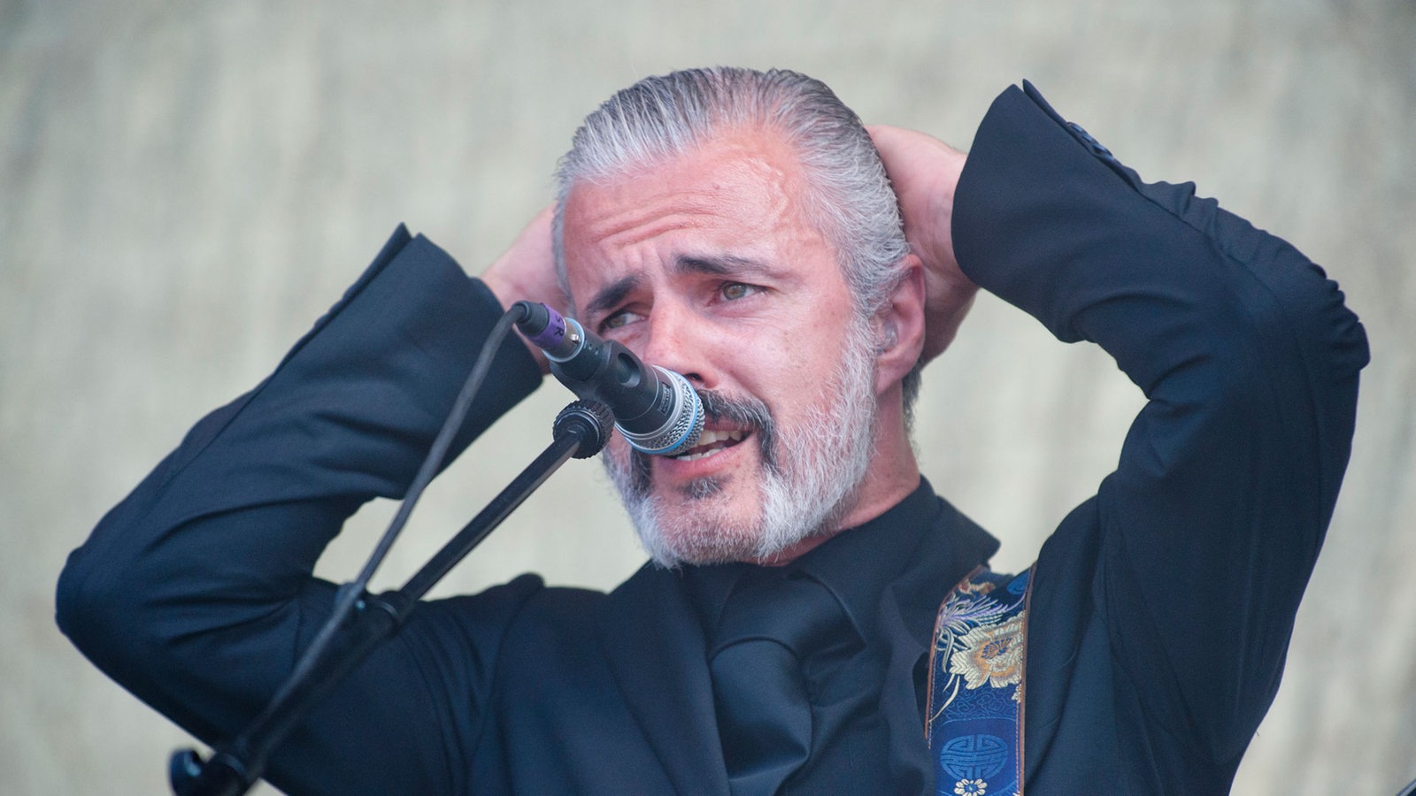 Sänger der Band Triggerfinger singt und verschränkt die Hände hinter dem Kopf