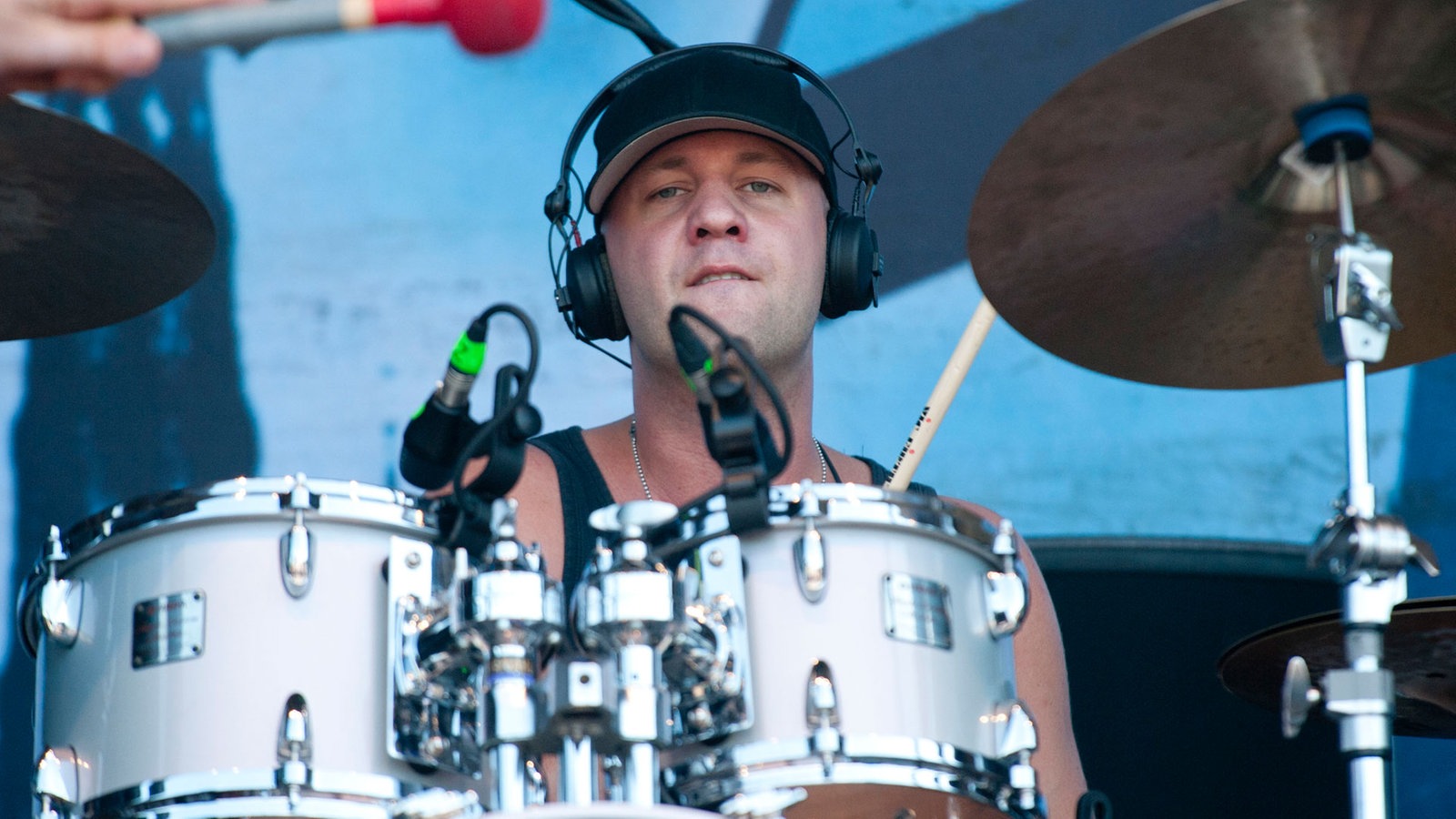 Drummer mit Kappe und Kopfhörern am Schlagzeug