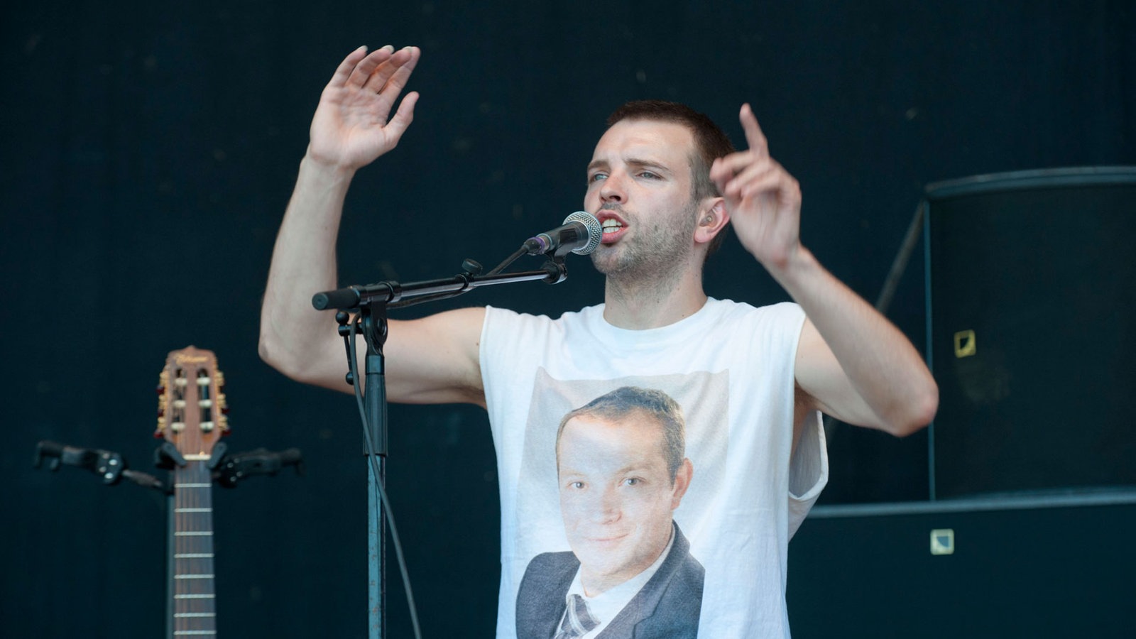 Sänger singt mit gehobenen Armen ins Mikrofon