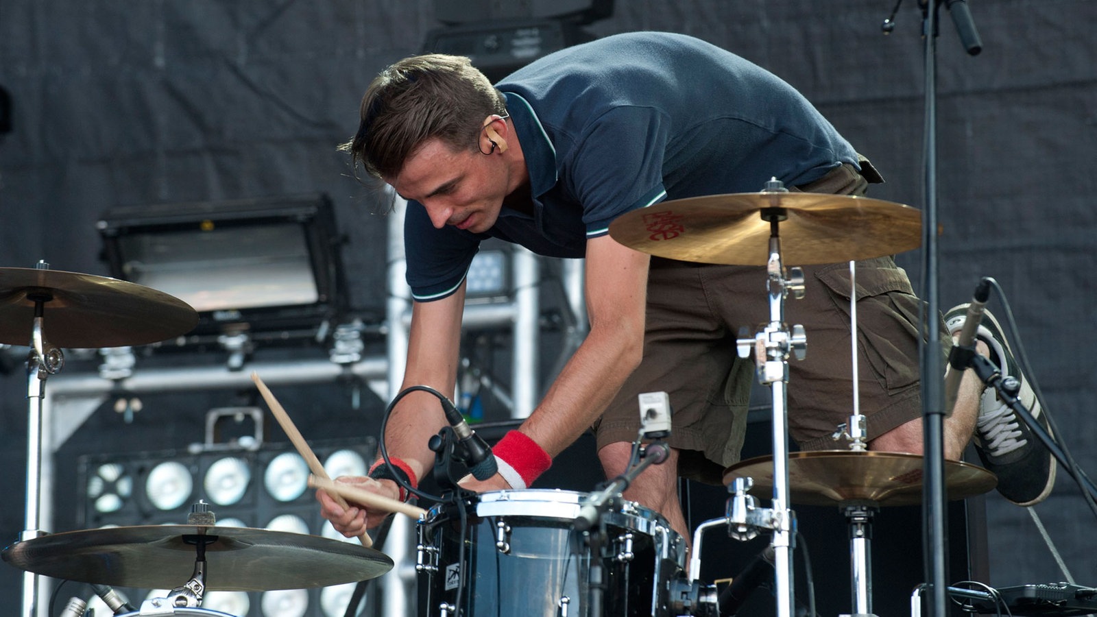 Drummer spielt nach vorne gebeugt und im Stehen