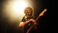 State Radio's Sänger verändert etwas an seiner Gitarre